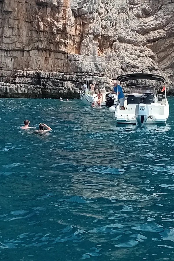 бројне барке и туристи у мору испред Плаве шпиље