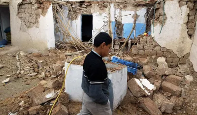 Alaoui Abdelkarim walks by rubble of a destroyed house in the village of Ait-Kamra, Wednesday Feb.25, 2004. A strong earthquake Tuesday killed more than 550 people in a poor region of northern Morocco. Many survivors braved a chilly, wet night without a home in makeshift tents.The quake shook areas near the coastal city of Al Hoceima, an isolated but picturesque area between the Rif Mountains and the Mediterranean Sea. (AP Photo/Michel Spingler)