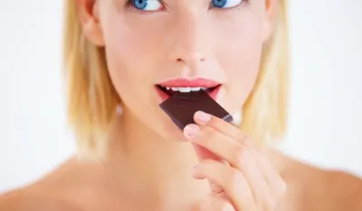 Young woman enjoying a delicious piece of chocolate