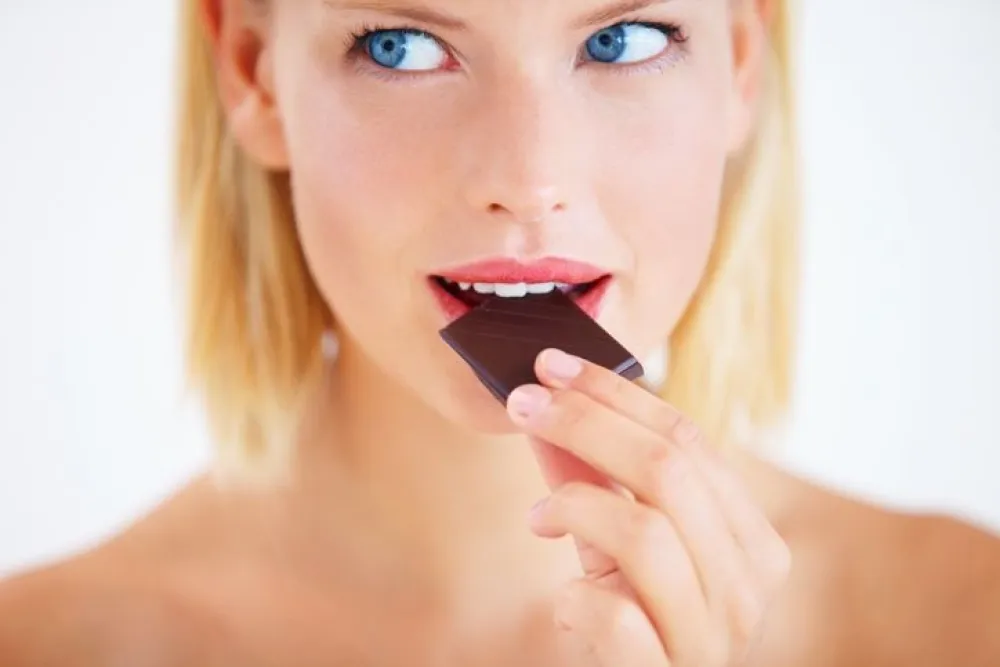 Young woman enjoying a delicious piece of chocolate