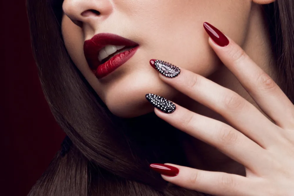 Pretty girl with unusual hairstyle, bright makeup, red lips and manicure design. Beauty face. Art nails. Studio portrait