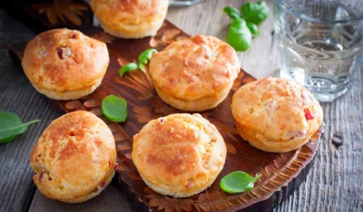 Muffins with ham and cheese on a wooden board, selective focus