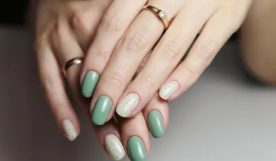 Female hands with nail design close-up. Beautiful female nails with green manicure