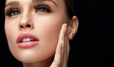 Beauty Woman Face. Portrait Of Beautiful Young Female With Perfect Facial Makeup, Soft Fresh Healthy Skin And Thick Long Black Eyelashes. High Resolution