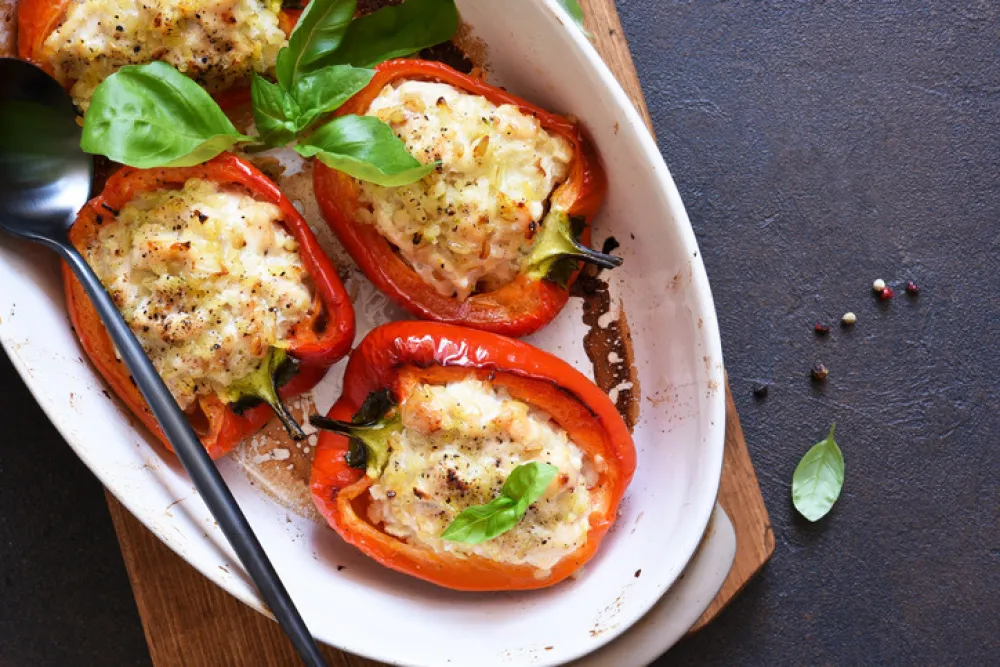 Baked bell pepper with meat and rice on a concrete dark background.