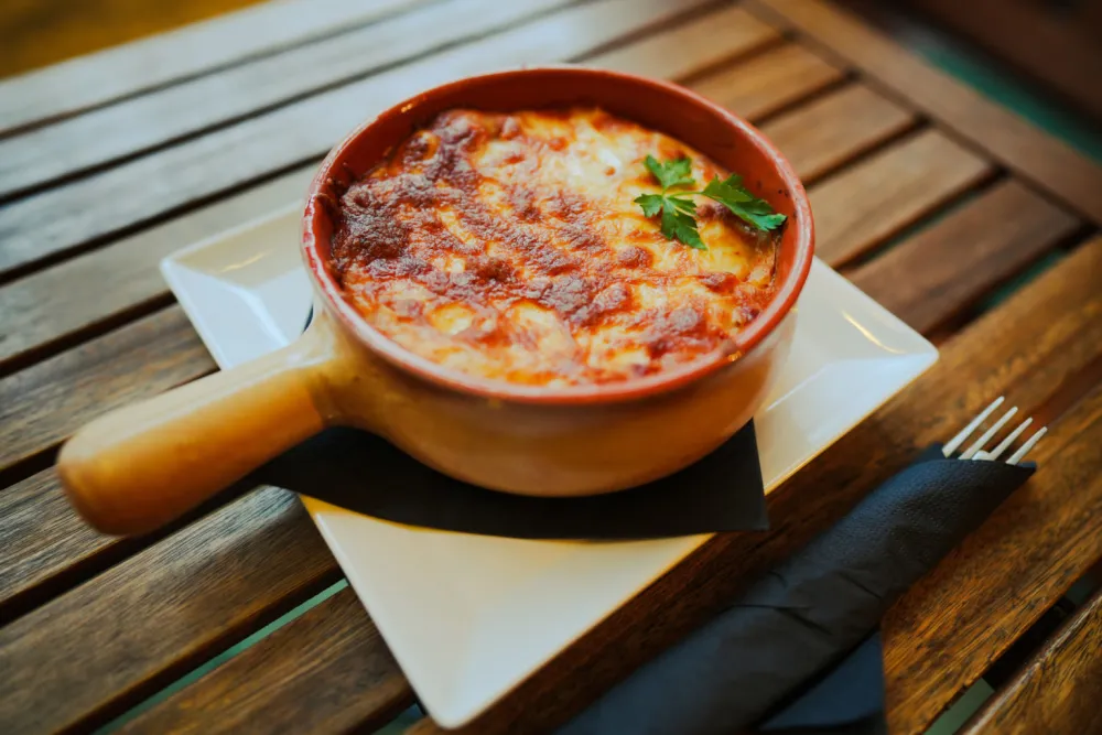 Close up shot of a freshly baked lasagna in a round pot.