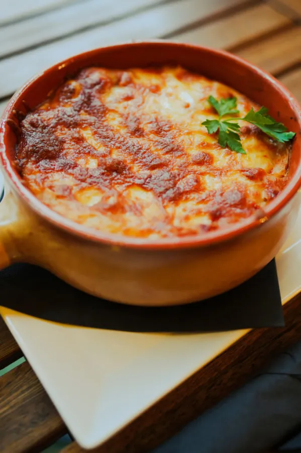 Close up shot of a freshly baked lasagna in a round pot.
