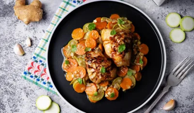 Moroccan spiced chicken with zucchini and carrots in a plate. toning