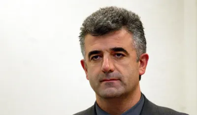 Dusko Jovanovic sits during his initial appearance before the War Crimes Tribunal in The Hague, December 5, 2003. Jovanovic, editor in chief of the paper DAN in Montenegro, has published the real name of the protected witness K32. He is being charged with contempt of the tribunal.  REUTERS/Pool