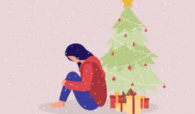 One Young Woman With Anxiety Sitting On Floor With Christmas Tree And Present. Isolated On Color Background.