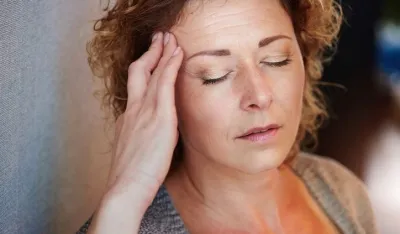 Close up portrait of older woman with hand to head in pain
