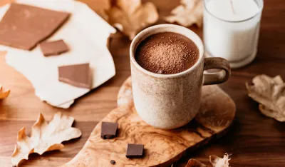 Close-up of hot chocolate in a ceramic mug on the table. Autumn or winter cozy still life.