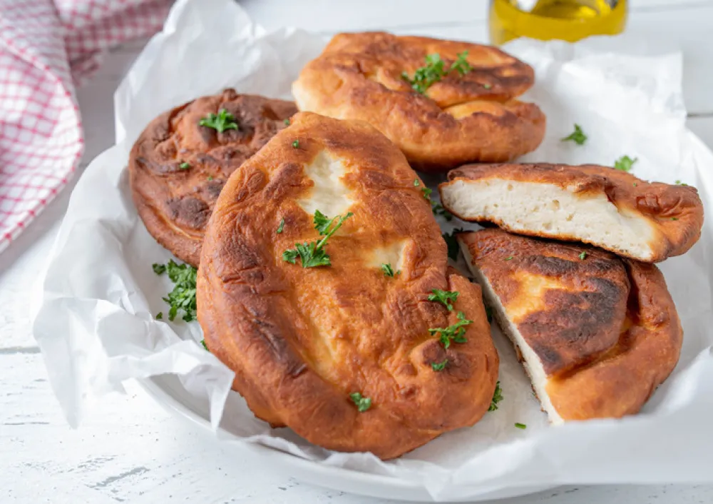 Delicious homemade pan fried langos. Tasty hungarian flatbread made with yeast dough