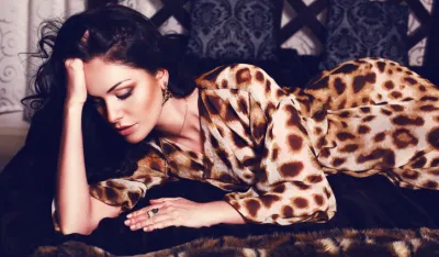beautiful woman in leopard print dress lying on sofa
