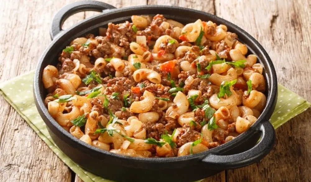 American Hamburger Goulash with Elbow Macaroni closeup in the pan on the wooden table. Horizontal<br>