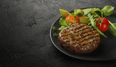 Fresh grilled burger cutlet with salad leaves on plate