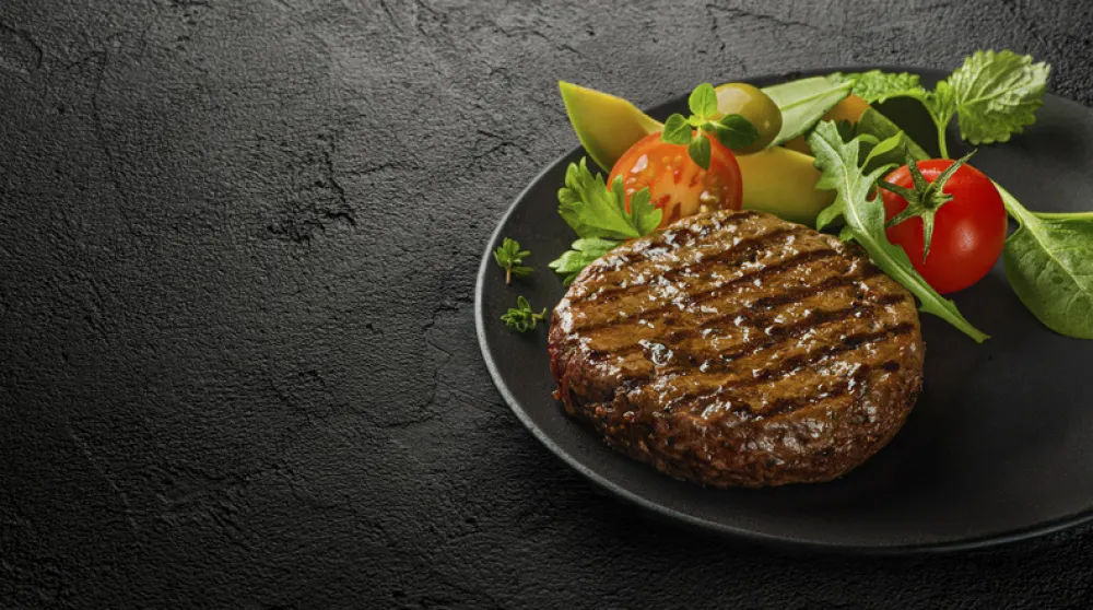 Fresh grilled burger cutlet with salad leaves on plate