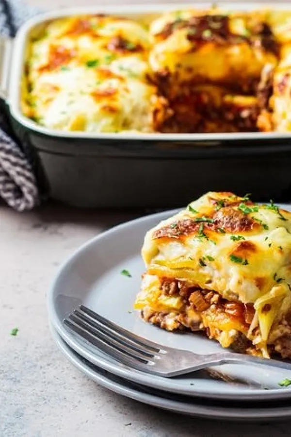 Traditional Greek potato and meat casserole with cheese - moussaka, dark background. Greek cuisine concept.