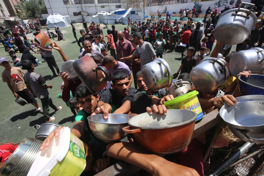 (FOTO) Raste očaj u Pojasu Gaze: Gladni Palestinci istovarili kamione sa hranom