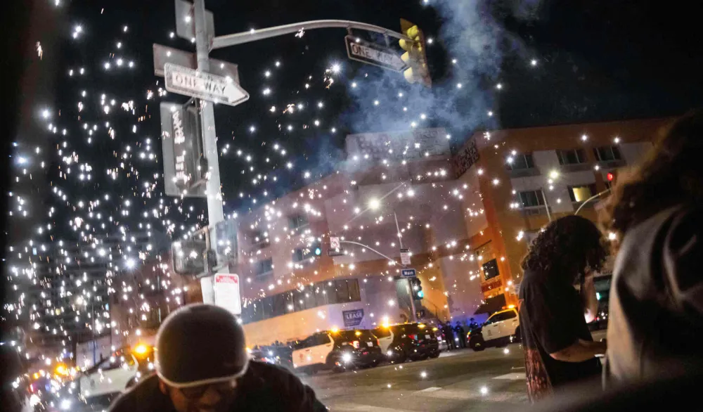 Ljudi se skrivaju od eksplozije vatrometa tokom protesta u blizini Metropolitanskog pritvorskog centra u centru Los Anđelesa, 8. juna 2025.