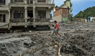 Ljudi hodaju po blatu i nanosu u oblasti Devighat u okrugu Nuakot u Nepalu u petak, 28. avgusta 2026. godine, nakon razorne bujične poplave.